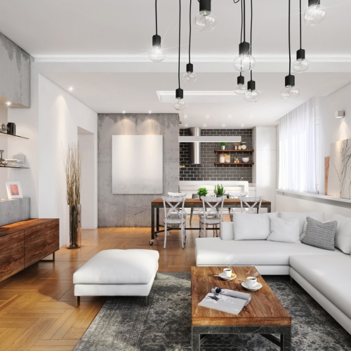 Ein helles Wohnzimmer mit Wohnküche mit einer großen, weißen Couch im Raum - und Tafelheizung